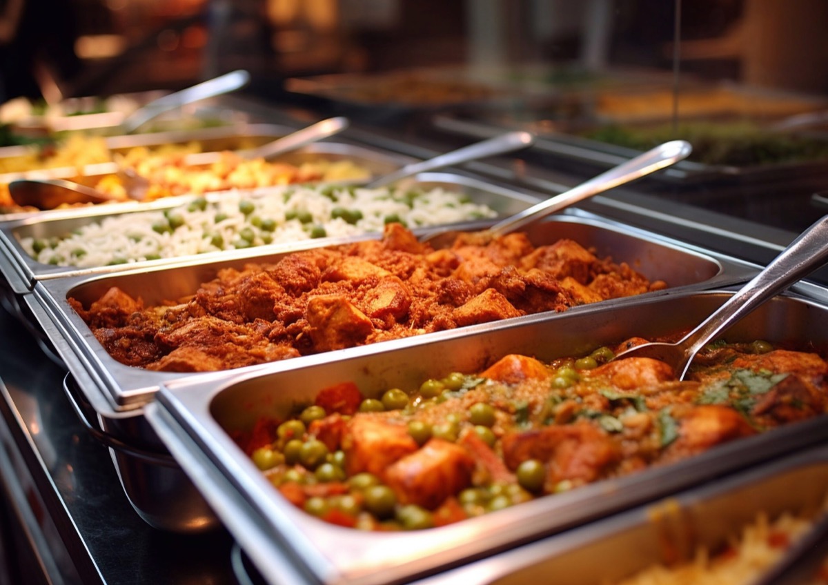 Close-up buffet trays of rice and curries for a pooja gathering